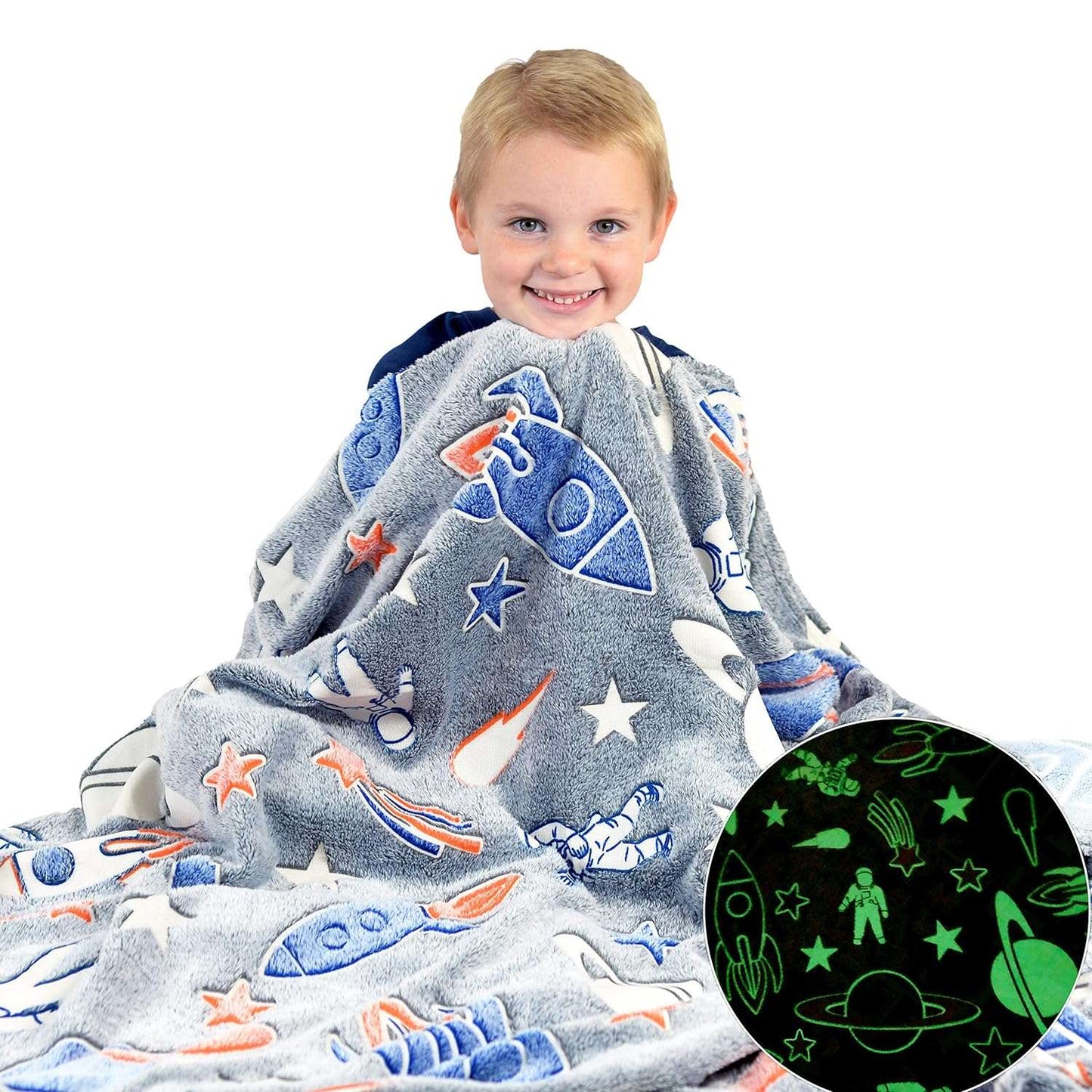 Child wrapped in a glow-in-the-dark space-themed blanket with rockets and astronauts
