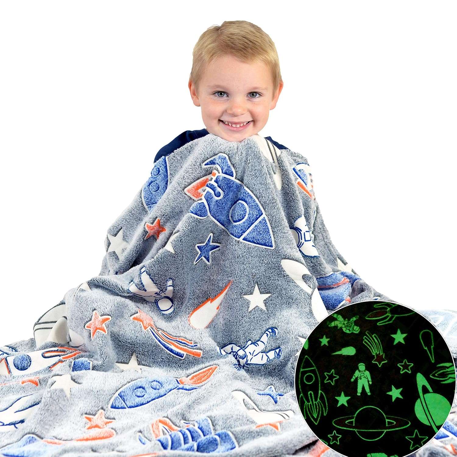 Child wrapped in a glow-in-the-dark space-themed blanket with rockets and astronauts