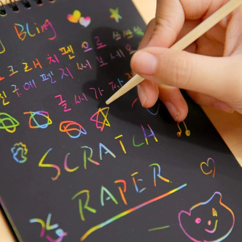 NIYO TOYS colorful scratch paper return gift being etched with a wooden stylus showing vibrant rainbow patterns