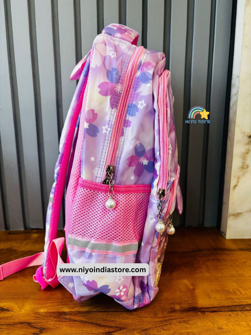 Side view of a purple Kuromi school backpack with floral designs and mesh pockets.