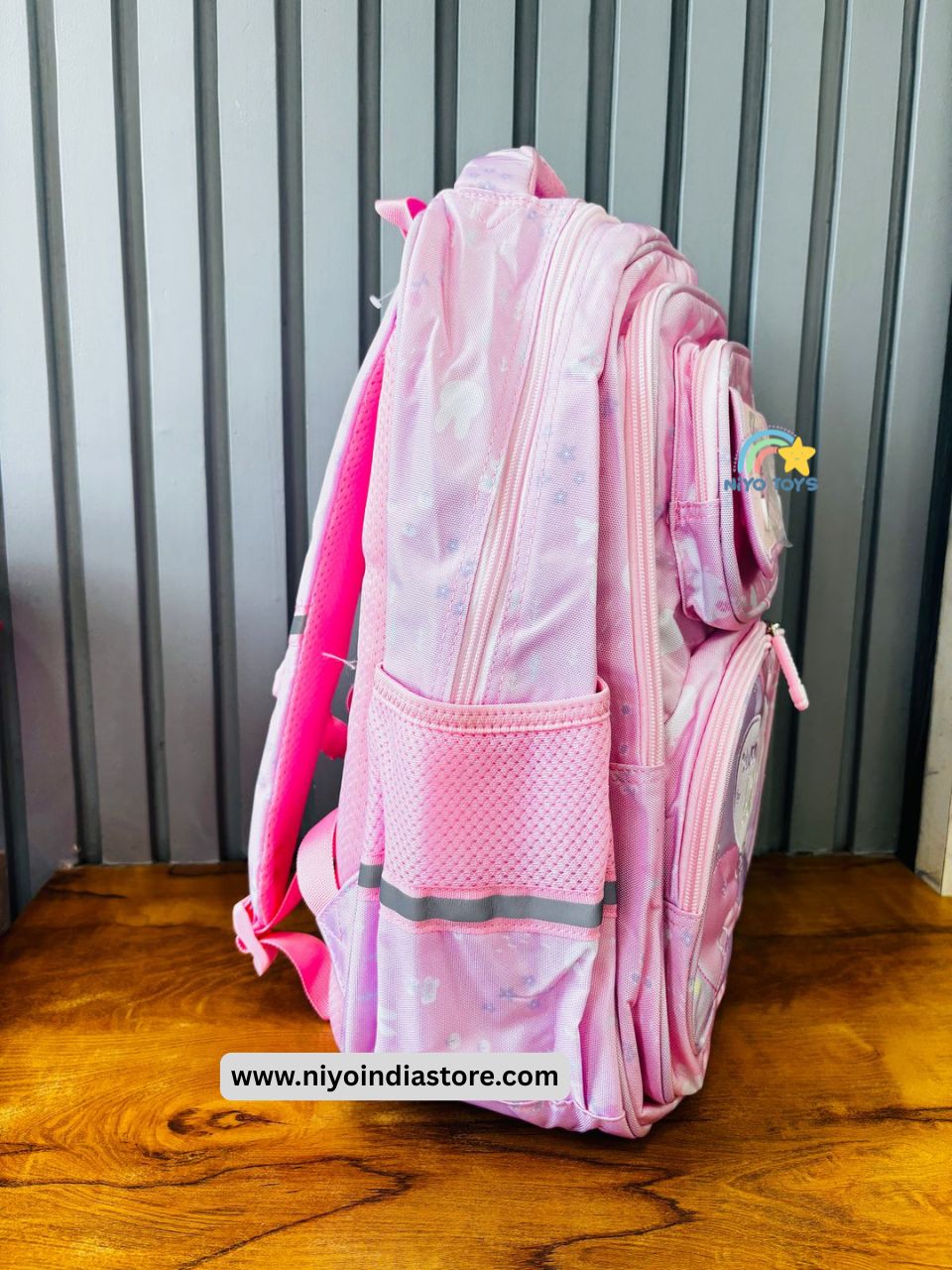 Side view of a NIYO TOYS premium girls school backpack in pink with mesh pocket