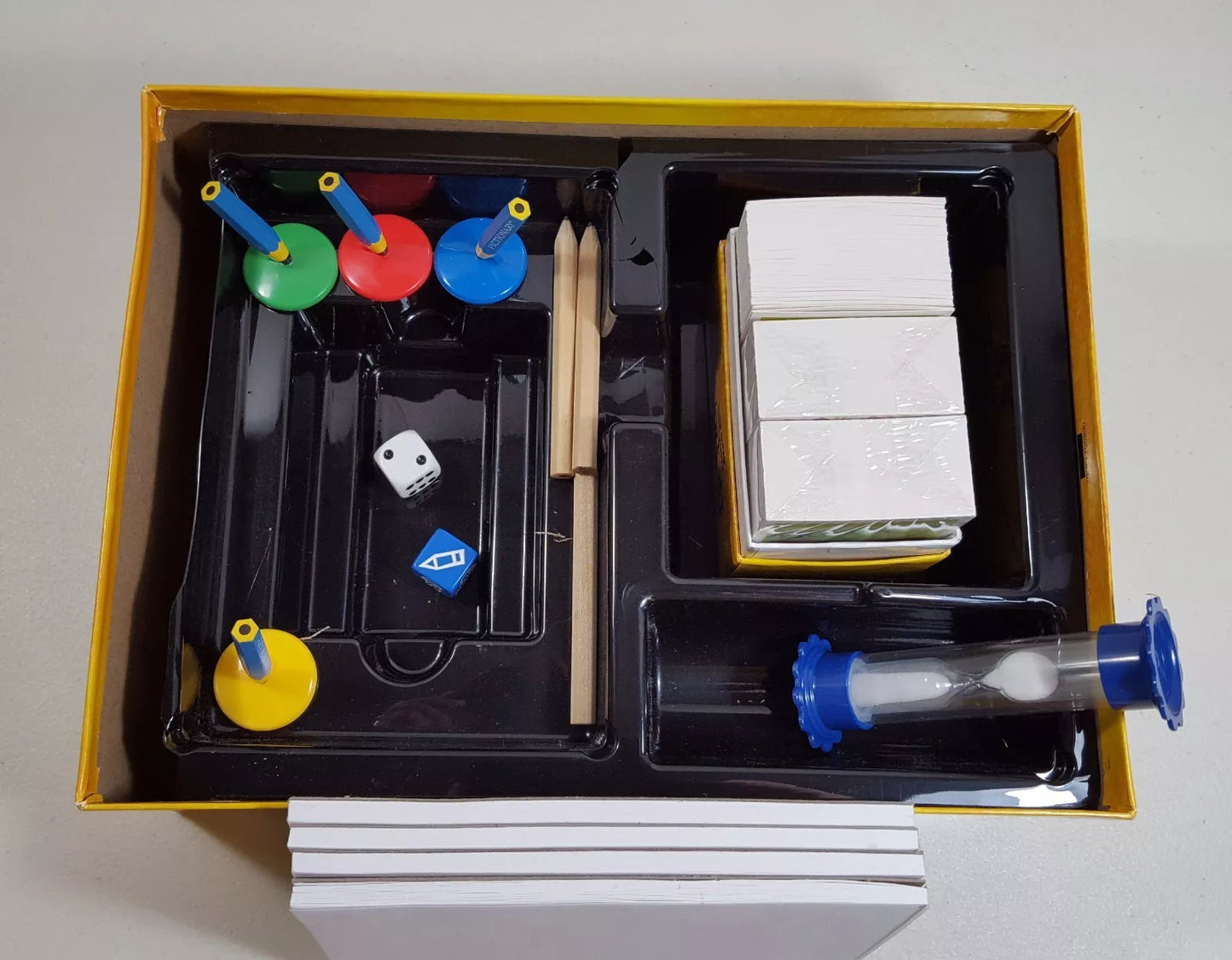 Pictionary game for kids featuring drawing tools, game pieces, and timer inside the box