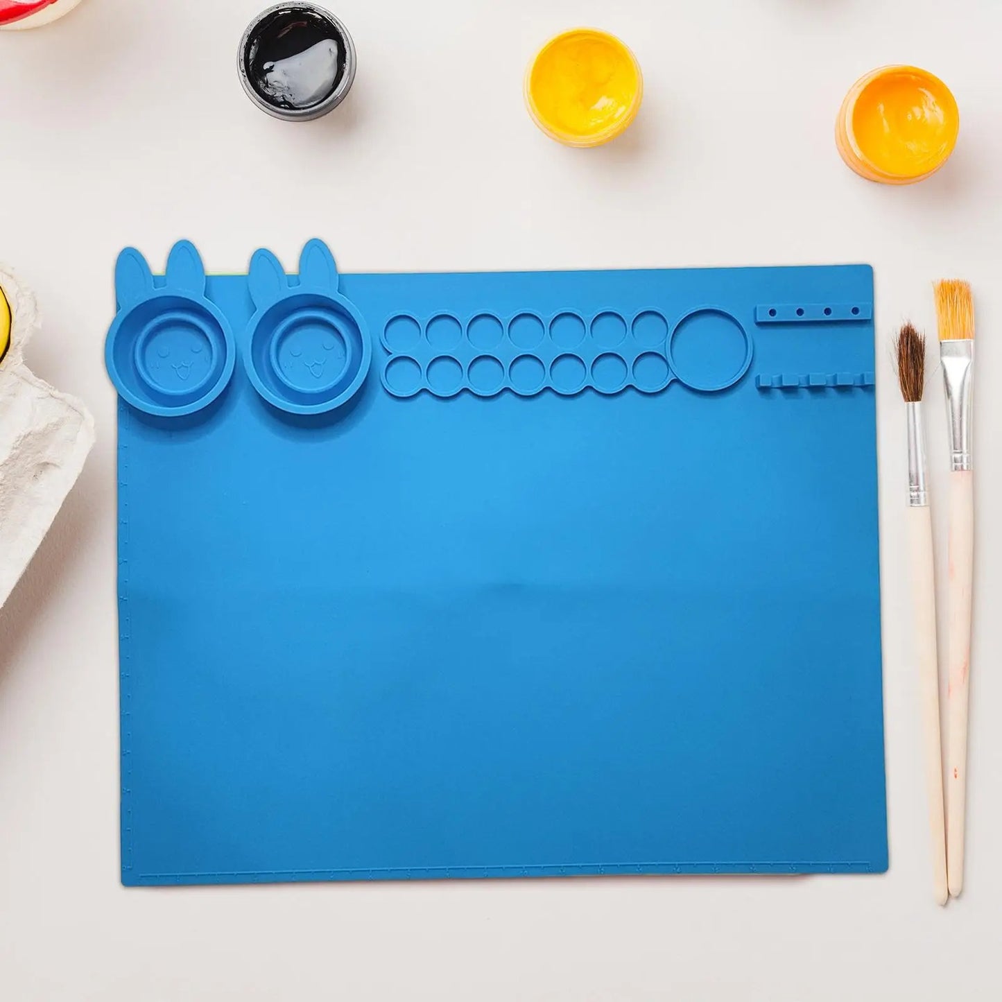 NIYO TOYS silicone art mat for kids in blue with sections for paints and brushes
