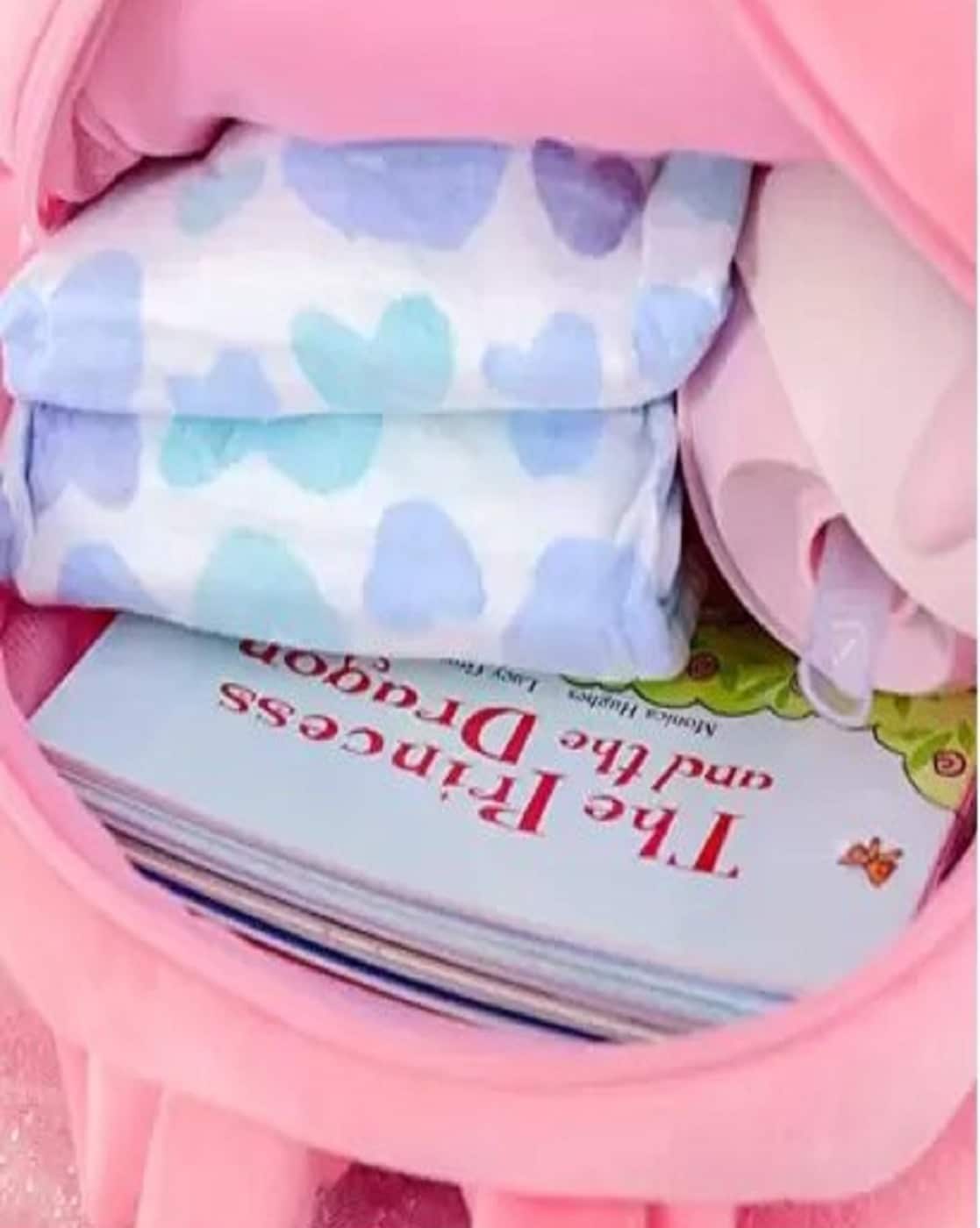 Pink kids backpack with heart-patterned items, books, and diapers, perfect for ages 3 and up