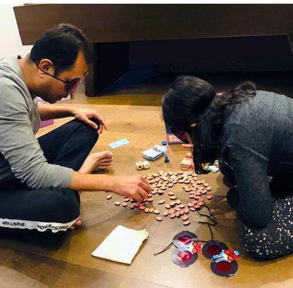 Family playing cross word game free on a wooden floor, using letter tiles and enjoying fun together