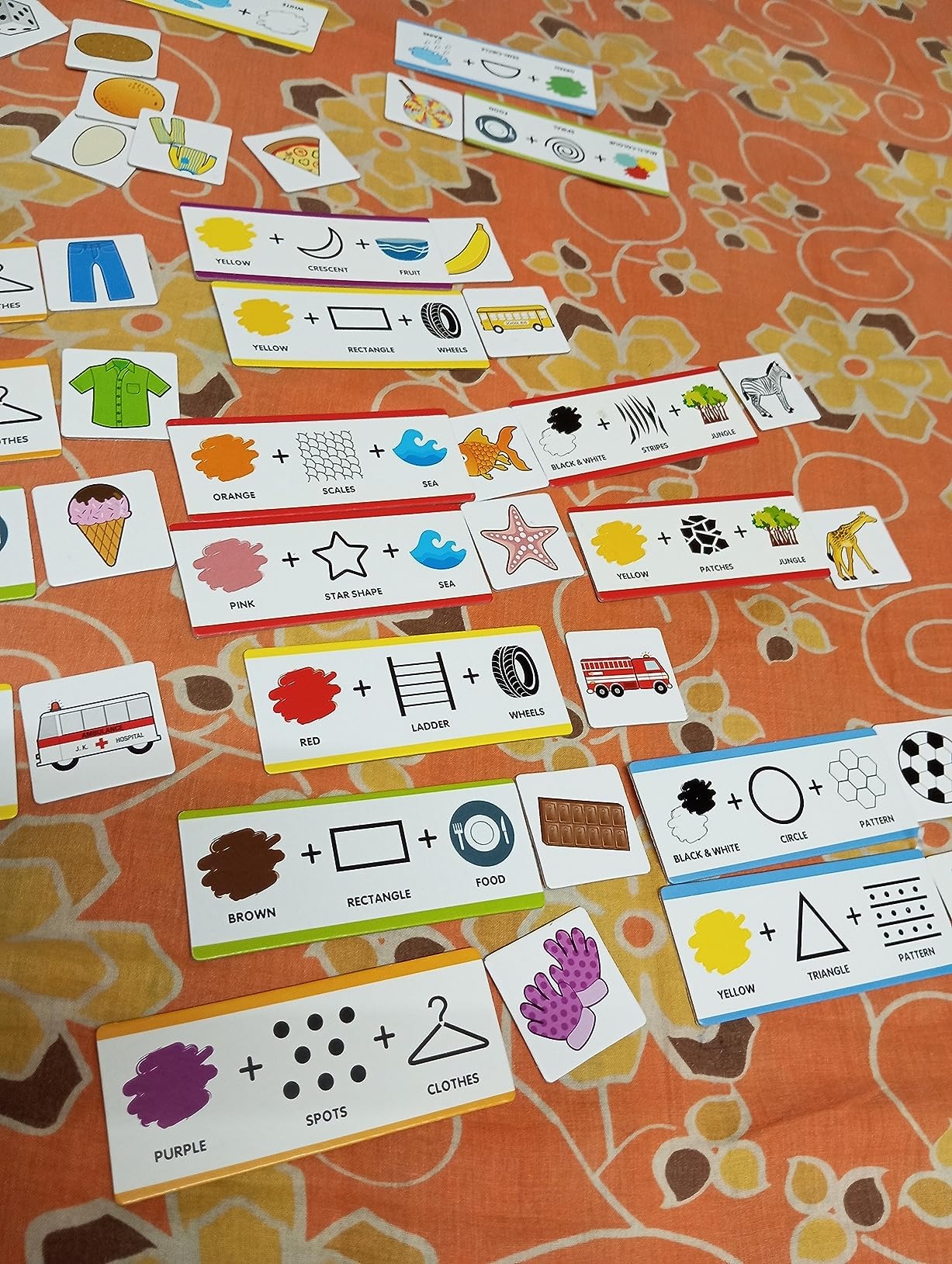 NIYO TOYS educational color and shape matching puzzle cards laid out on a patterned orange surface
