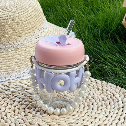 Cute glass tumbler with lid and straw, featuring pastel colors and pearl handle, perfect for kids