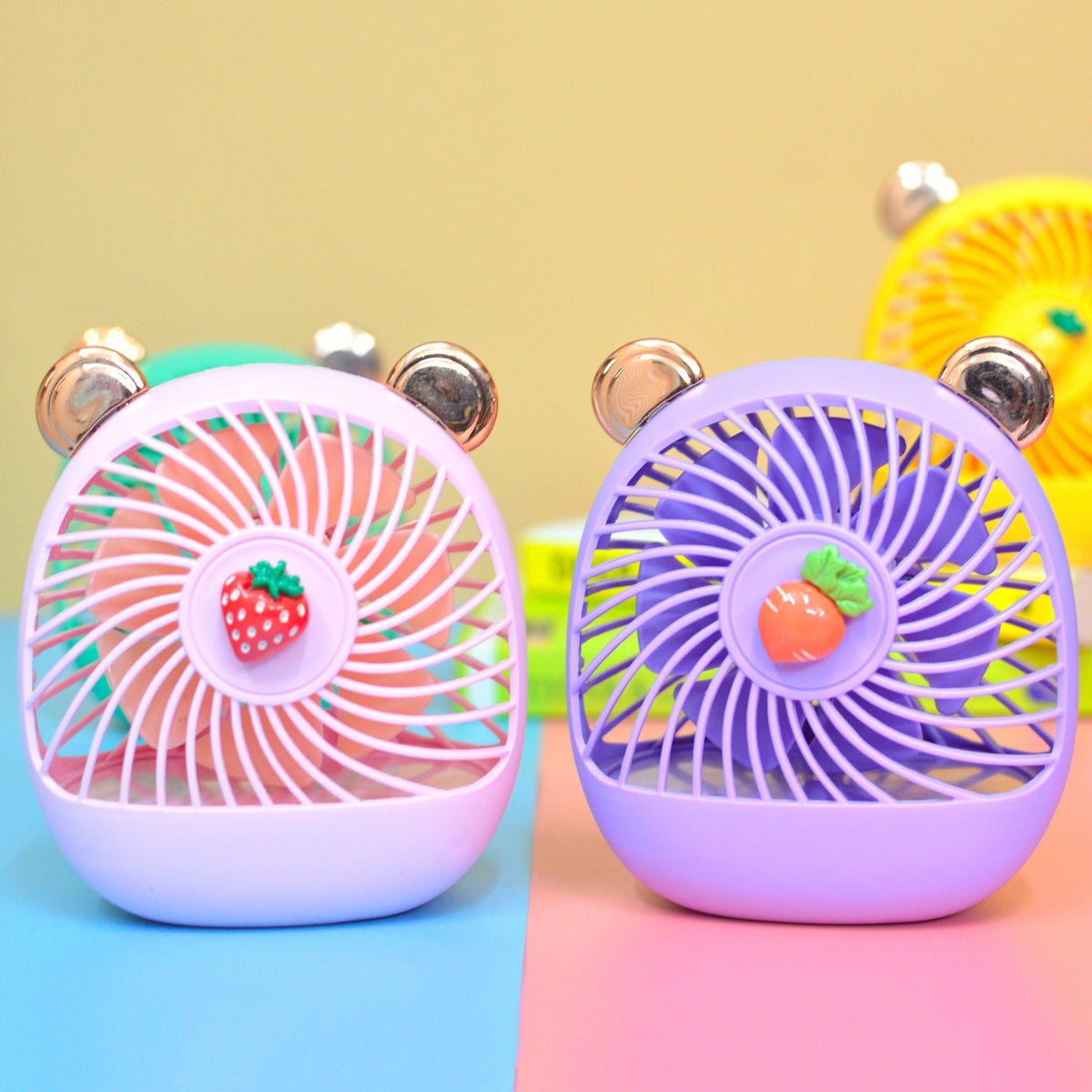 Colorful hand held fan in pink and purple with cute bear ears and fruit decorations for kids age 3 and up