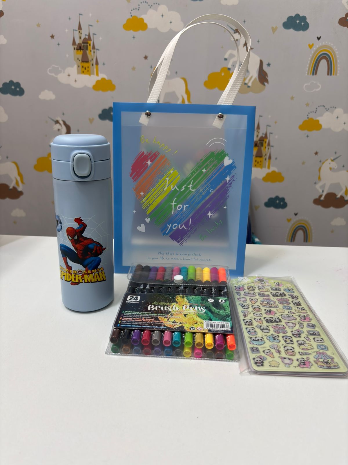 Colorful gift hamper for kids featuring Spider-Man water bottle and art supplies, ideas for gift hamper