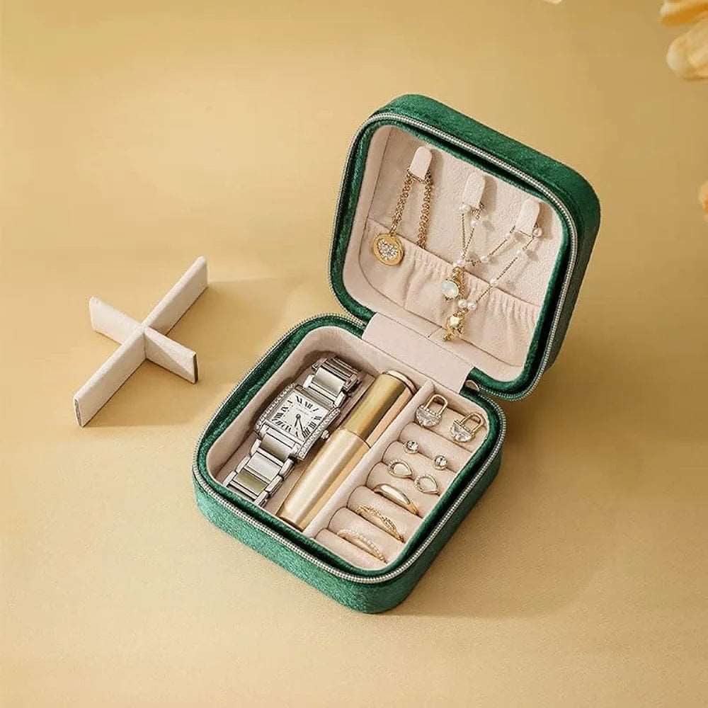 Green jewelry case for travel with compartments for rings, earrings, and a watch, ideal for organized trips