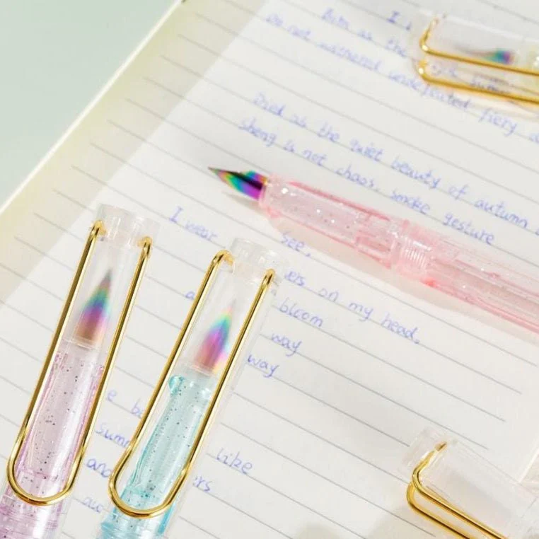 Colorful NIYO TOYS gel pens with glitter ink on a notebook page filled with handwritten notes