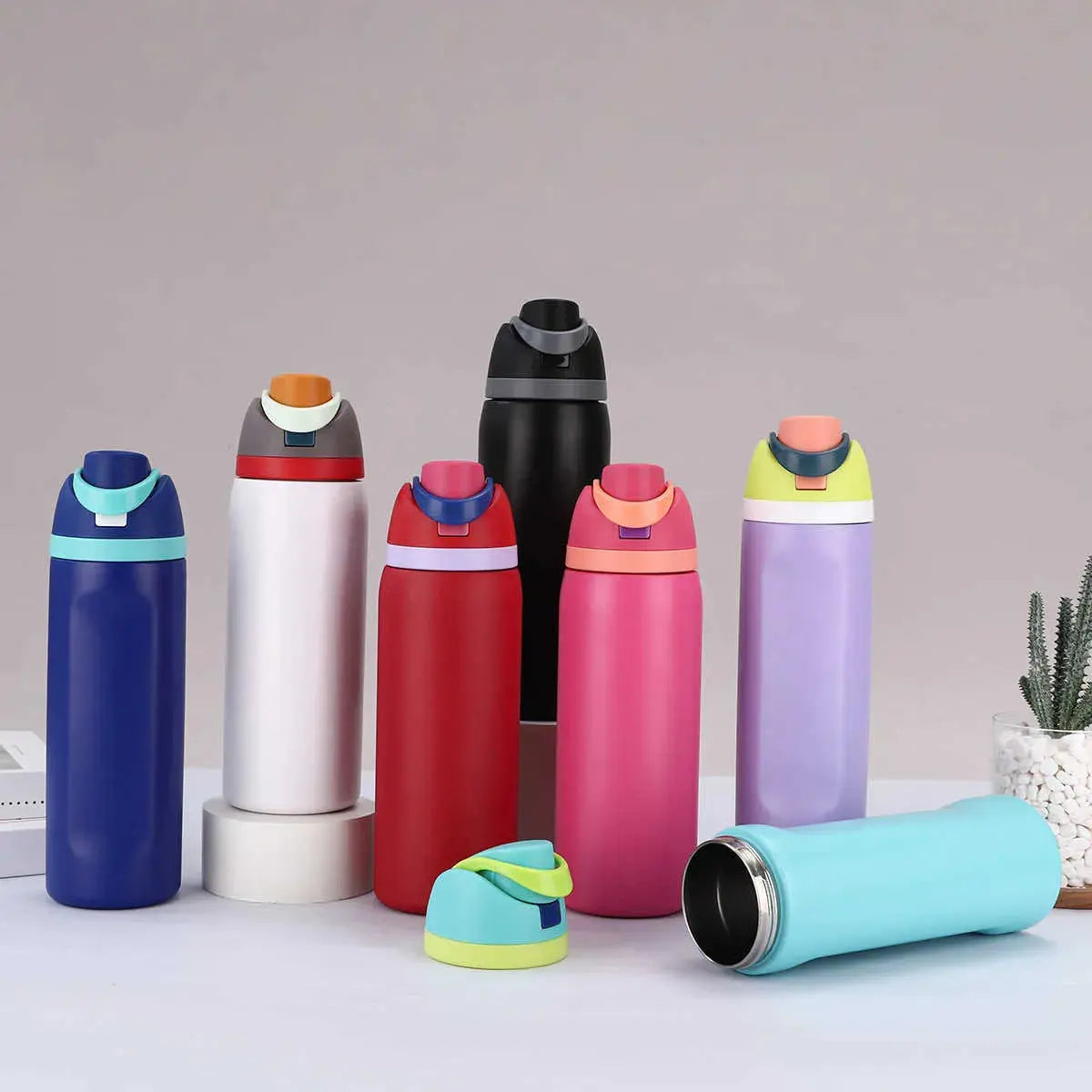Variety of Owala water bottles in different colors for kids and adults, perfect for hydration on the go