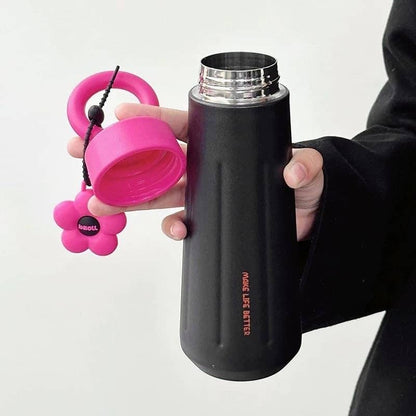 Black Owala water bottle with a pink cap and flower-shaped keychain, ideal for adults and daily hydration