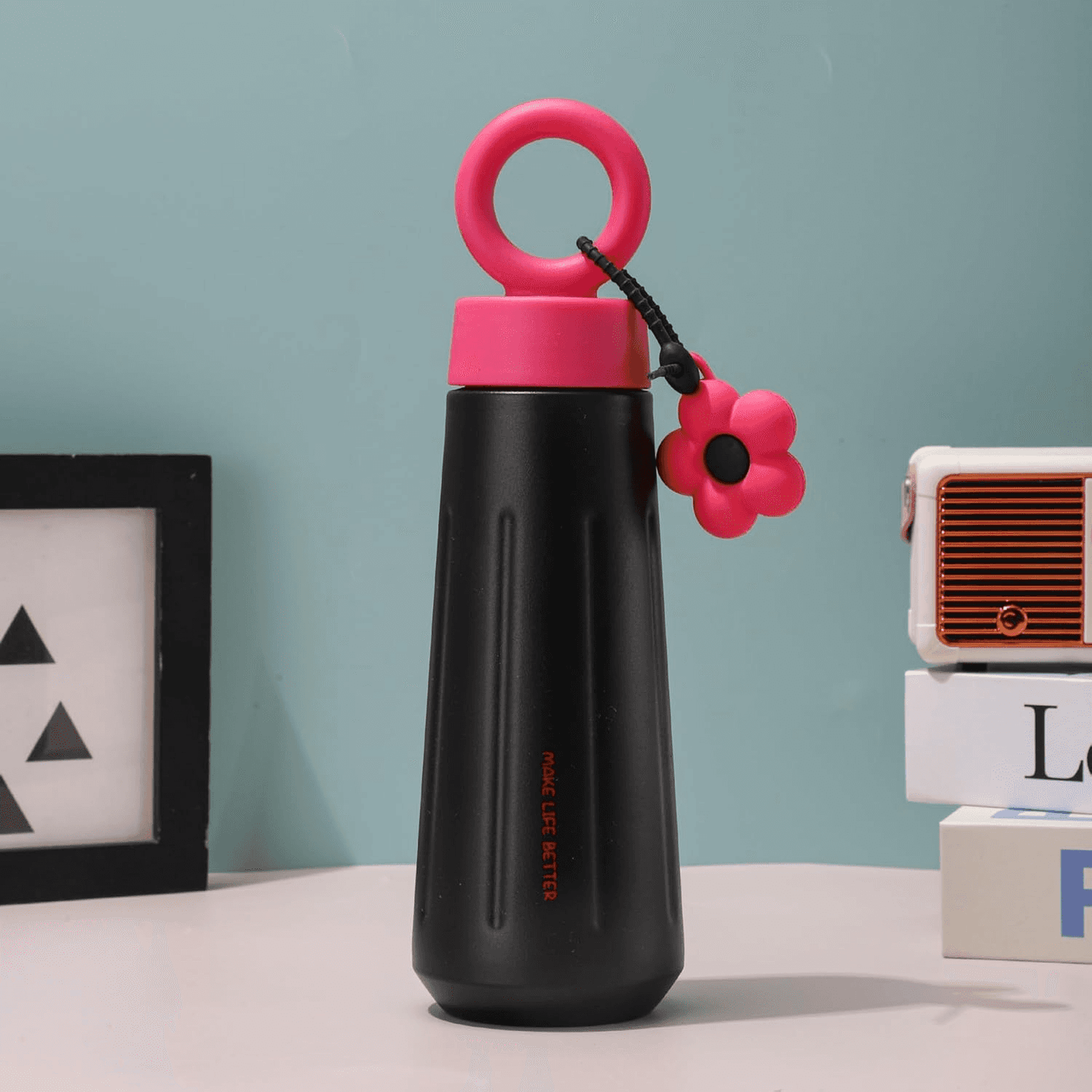 Black Owala water bottle with pink cap and flower charm, ideal for kids age 5+, perfect for school or sports