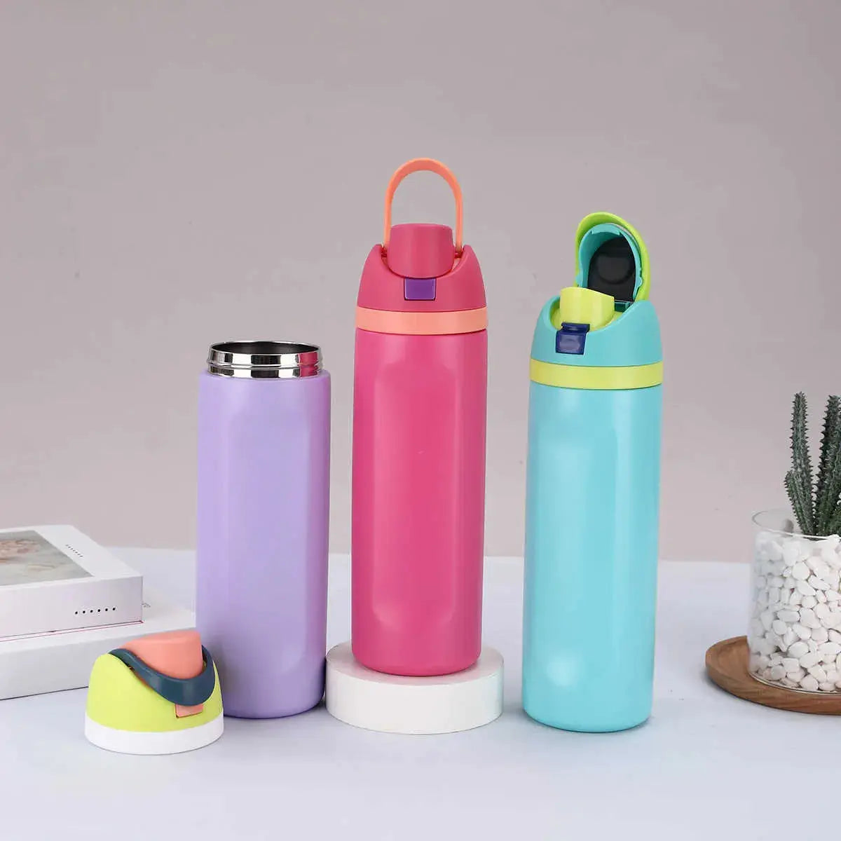 Set of colorful Owala water bottles in pink, purple, and blue for kids, ideal for hydration on the go