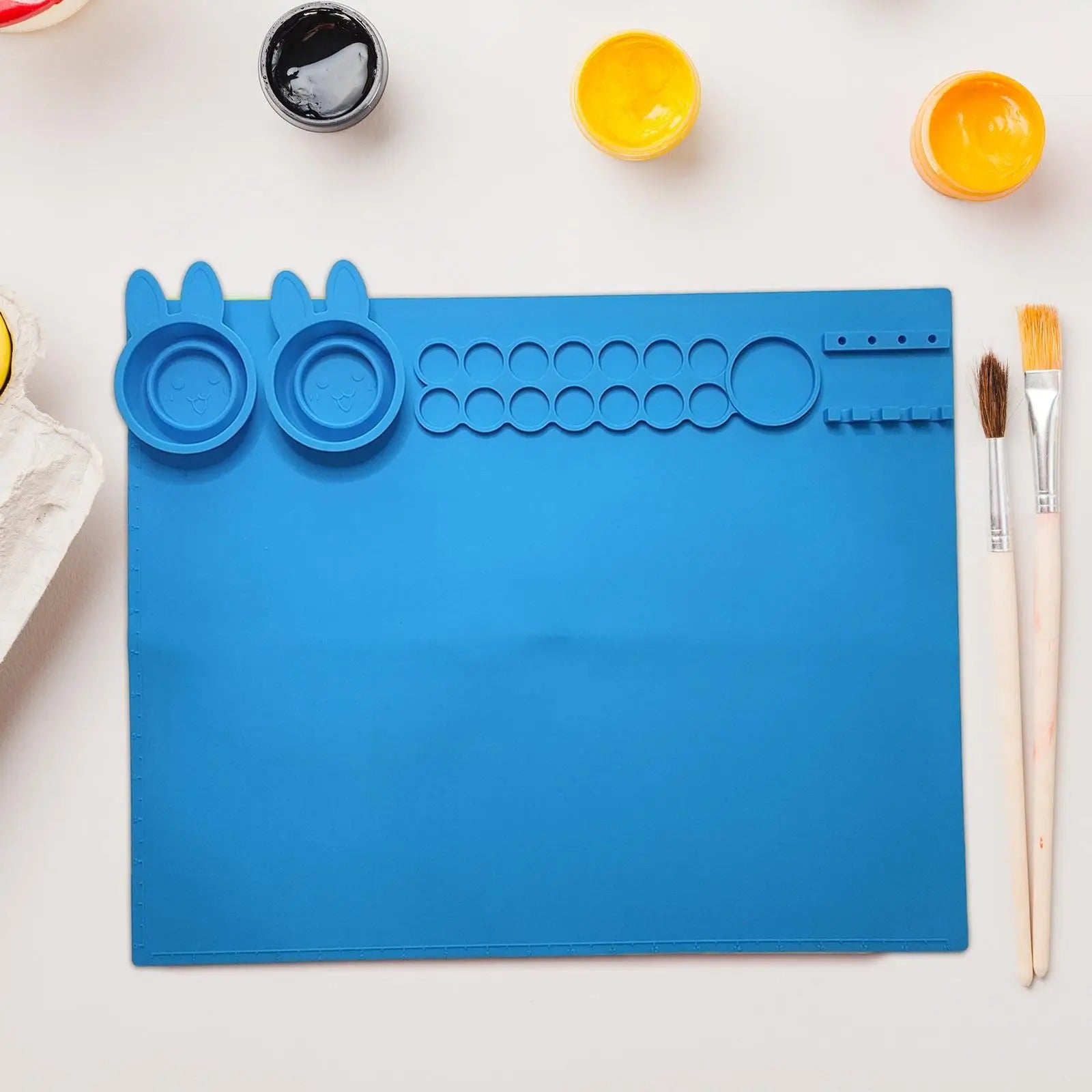 NIYO TOYS silicone art mat for kids in blue with sections for paints and brushes