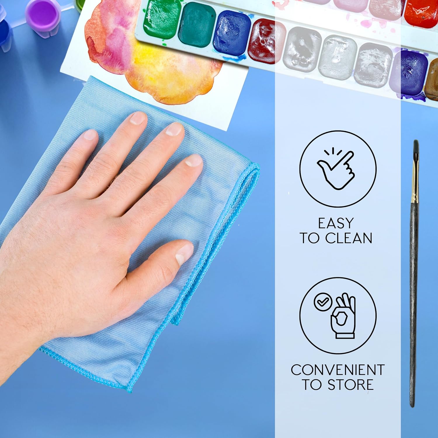 Silicone art mat for kids showing a hand cleaning the mat with vibrant paints and a paintbrush