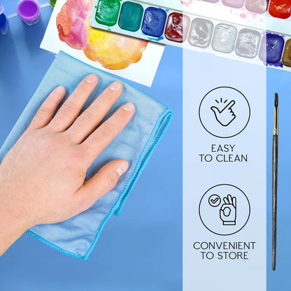 Silicone art mat for kids showing a hand cleaning the mat with vibrant paints and a paintbrush