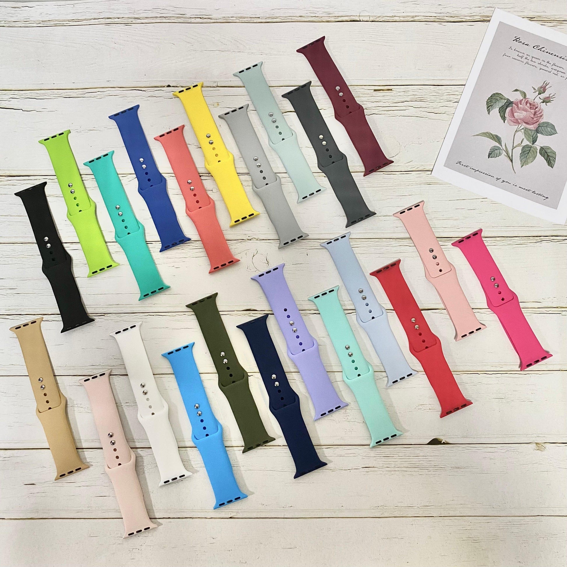 Colorful NIYO TOYS sports silicone band for iWatch in various shades and styles on a wooden surface