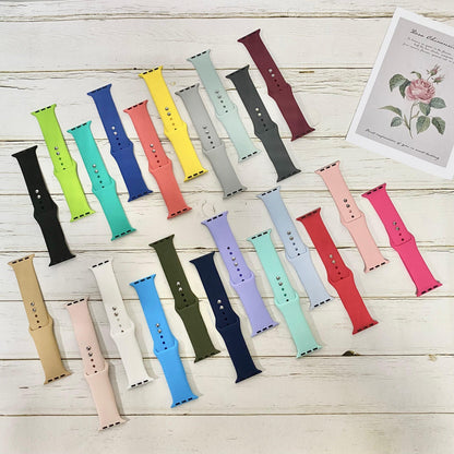 Colorful NIYO TOYS sports silicone band for iWatch in various shades and styles on a wooden surface